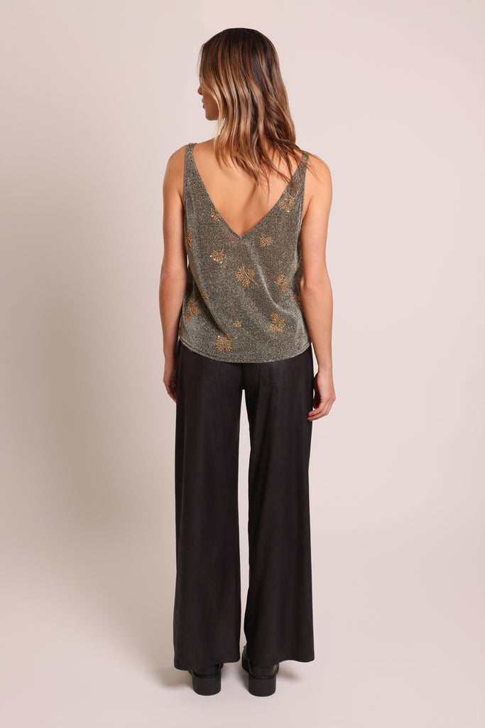 Back shot of model wearing a black and silver glittery gold beaded sleeveless V-neck vest top.