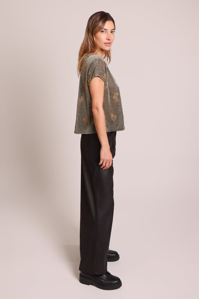 Side shot of model wearing a black and silver glitter gold beaded short sleeve slouch shirt.