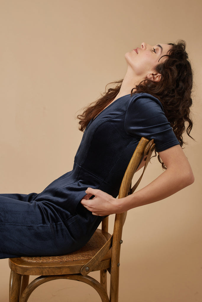 Navy Blue Corduroy Short Sleeve V Neck Women's Jumpsuit Side Sitting Model Shot