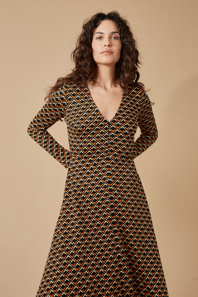 Black and Orange Geometric Print Long Sleeve V Neck Midi Dress Close Up Front Model Shot