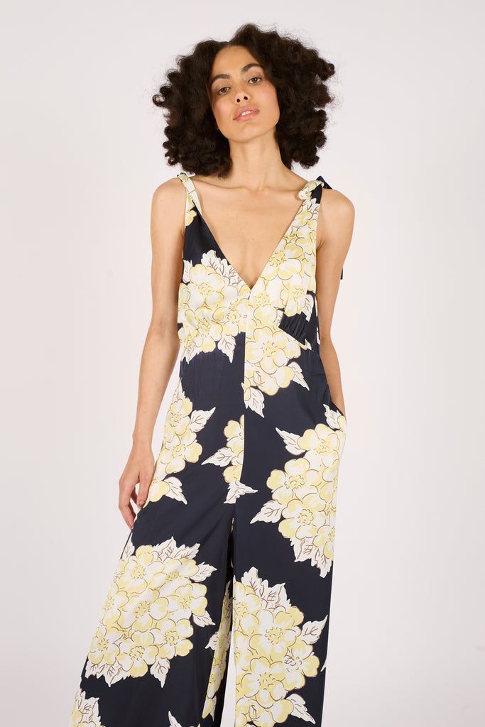Close Up Front Model Shot of Navy Blue and Cream Floral Tie trap Wide Leg Women's Jumpsuit.
