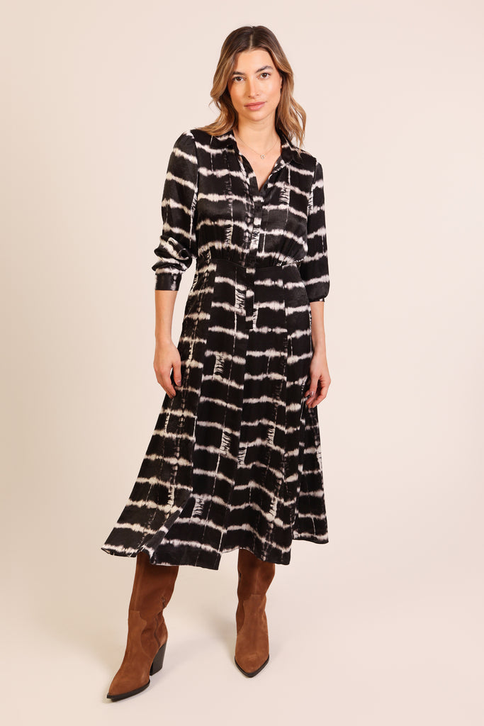 Front shot of model wearing a black and white brick wall print button front three quarter sleeve midi dress.