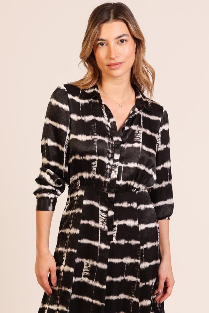 Close up front shot of model wearing a black and white brick wall print button front three quarter sleeve midi dress.