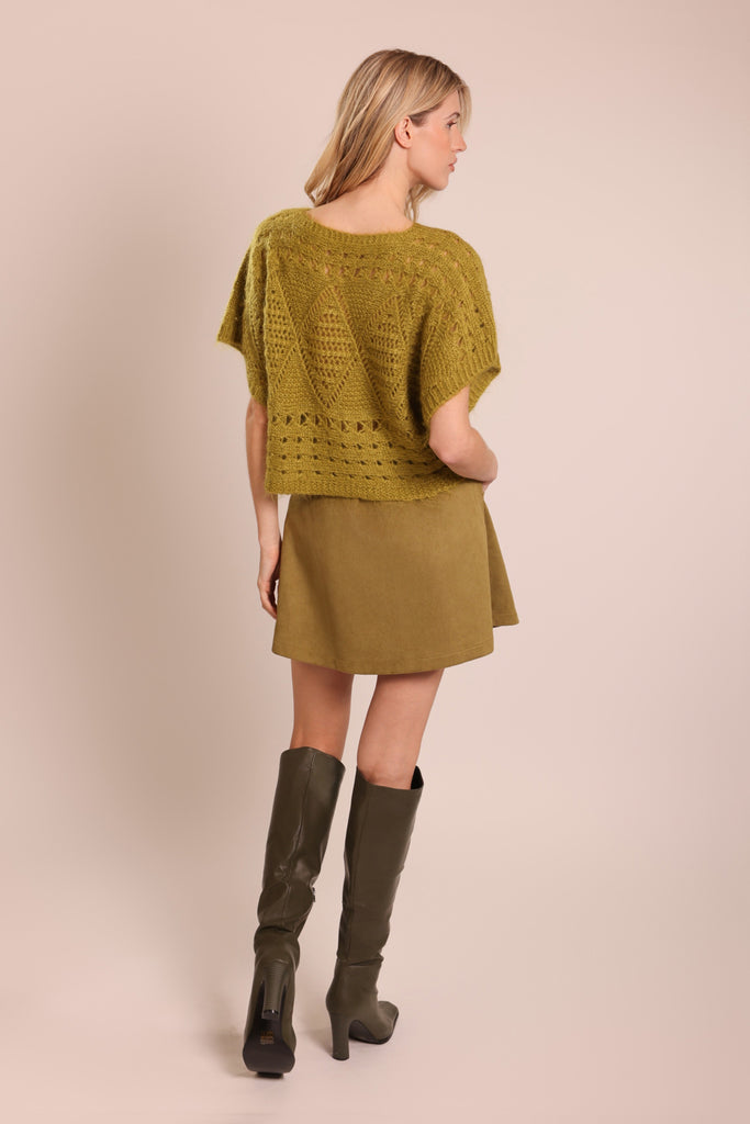 Back shot of model wearing a green knitted short sleeve relaxed fit jumper.