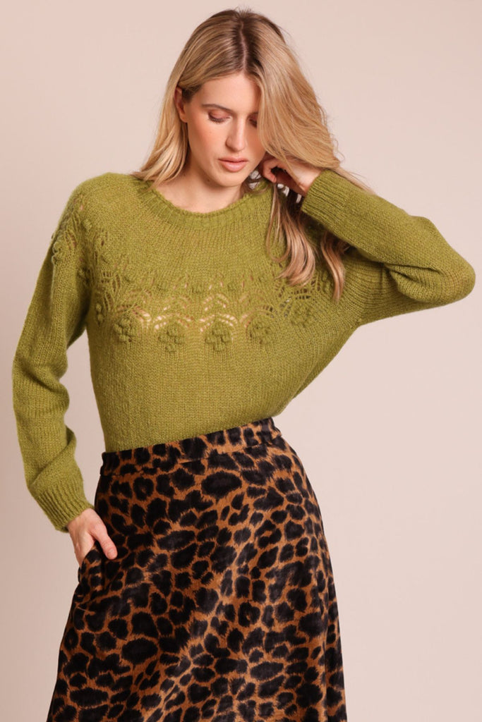 Close up front shot of model wearing a green knitted long sleeve round neck jumper.