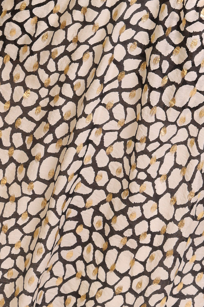 Swatch for white black and gold print dress fabric.